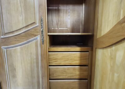Open wooden wardrobe with empty shelves.