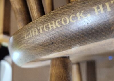 Close-up of wooden chair with engraved text.