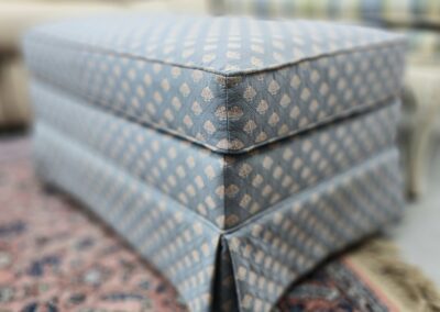 Patterned ottoman on a decorative rug.