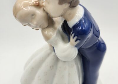 Porcelain figurine of couple embracing gently.