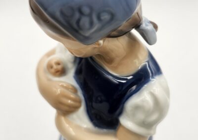 Ceramic figurine of woman holding baby.