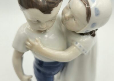 Porcelain figurine of two embracing children.