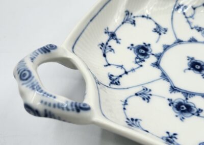 Blue and white floral ceramic dish handle.