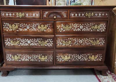 Ornate wooden dresser with floral inlay design.