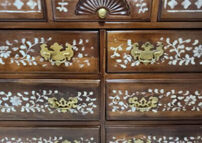 Wooden chest with white floral patterns.