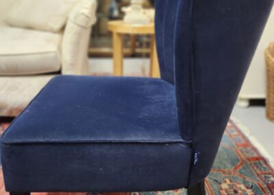 Blue velvet chair on patterned rug.