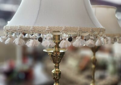 Decorative brass lamp with tasseled shade.