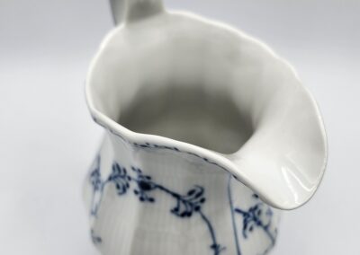 White ceramic pitcher with blue floral design.