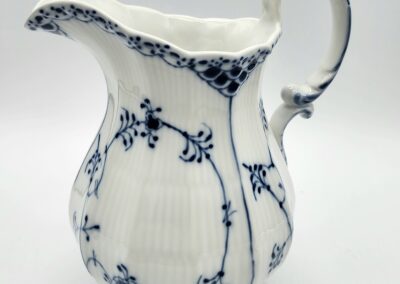 White ceramic pitcher with blue floral design.
