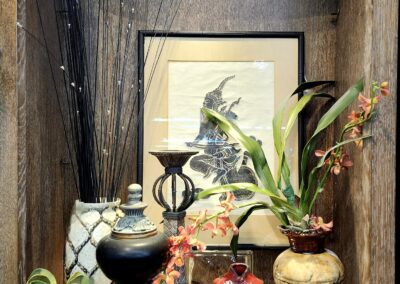 Decorative shelf with plants and art objects.