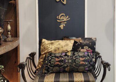 Chair with decorative pillows and Chinese calligraphy.