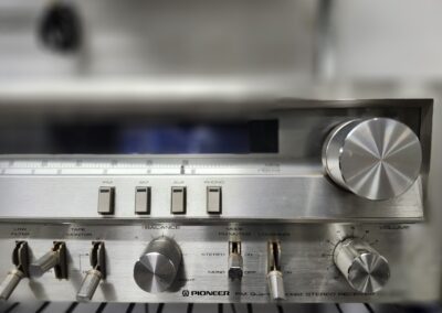 Vintage silver stereo receiver with control knobs.