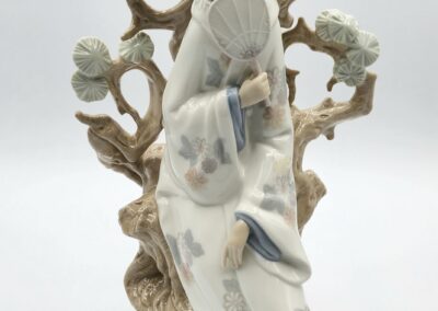 Porcelain figurine of a woman with fan.
