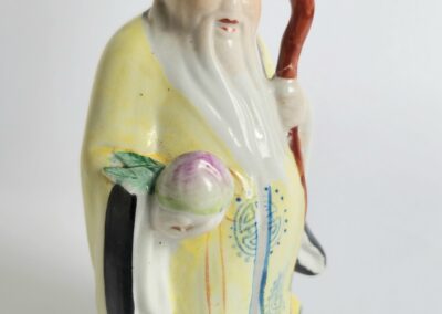 Elderly figurine holding peach and staff.