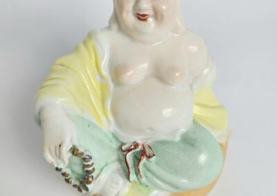 Ceramic laughing Buddha figurine holding beads.