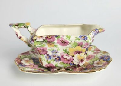 Floral patterned gravy boat with saucer.