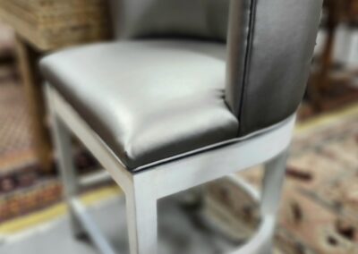Silver upholstered bar stool in a room.