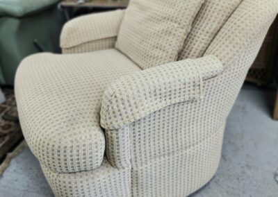 Beige upholstered armchair in a room.