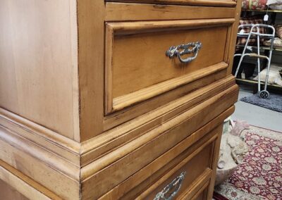 Wooden dresser with ornate metal handles.