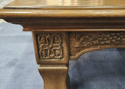 Ornate wooden table corner with carved details.