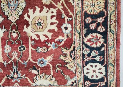 Red and beige traditional patterned rug corner.