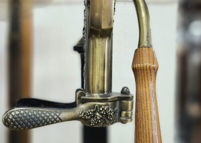 Vintage brass hand-crank machine with handle.