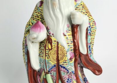 Porcelain figurine of elderly man with peach.