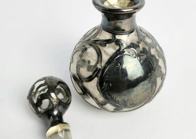Ornate silver and glass perfume bottle.