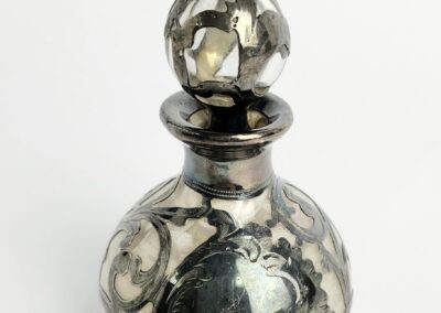 Ornate silver perfume bottle with stopper.