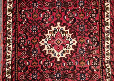 Red and white intricate patterned Persian rug.