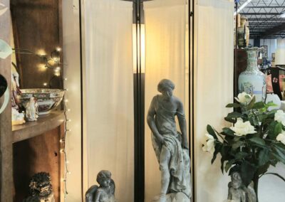 Indoor fountain with decorative statues and plants.