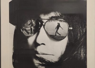 Person wearing sunglasses with reflections of dancers.