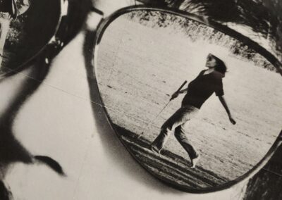 Reflection of walking person in sunglasses lens.