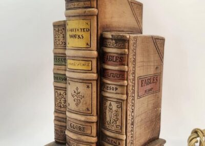 Wooden lamp base shaped like stacked books.