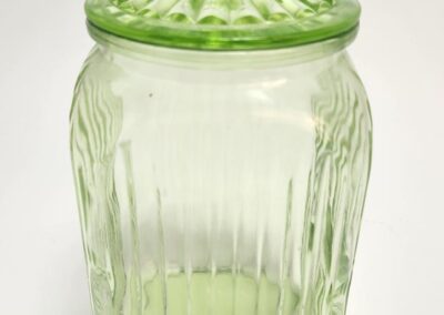 Green glass jar with decorative lid.