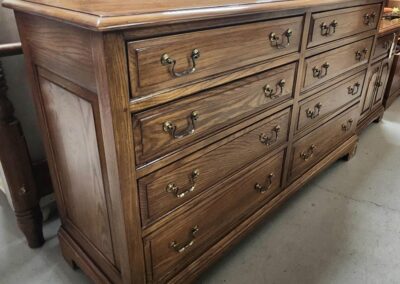 Wooden dresser with brass handles, nine drawers.