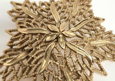 Intricate gold leaf-shaped decorative brooch.