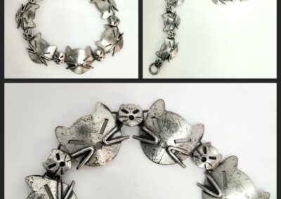 Silver cat-themed bracelet with detailed design.