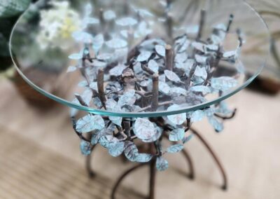 Glass top table with metal leaf design.