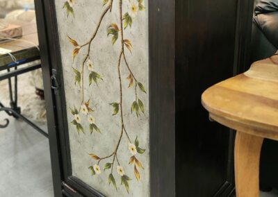 Decorative cabinet with floral branch design.