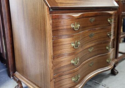 Antique wooden secretary desk with ornate handles.