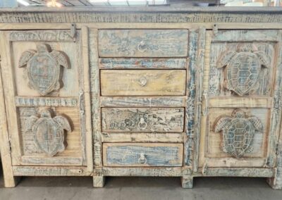 Rustic cabinet with carved turtle designs.