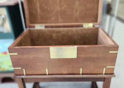 Open wooden chest on a stand.