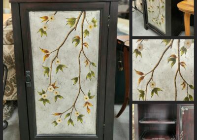 Dark cabinet with floral branch design.