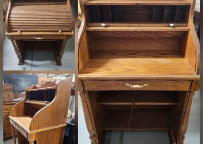 Wooden roll-top desk with multiple compartments.