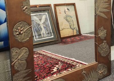 Decorative mirror with nature-themed frame design.