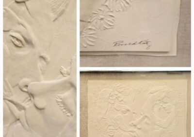 Embossed artwork featuring faces and flowers.