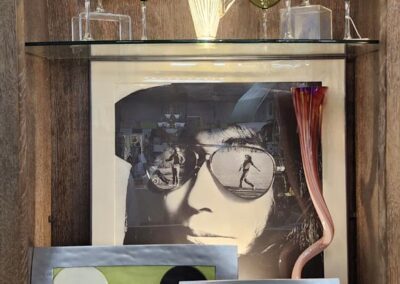 Decorative shelf with art and glassware.