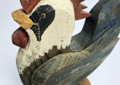 Wooden rooster sculpture with colorful details.