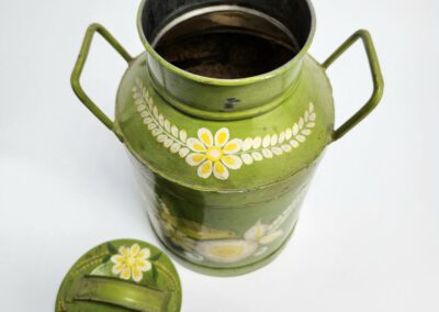 Green floral tin with open lid.